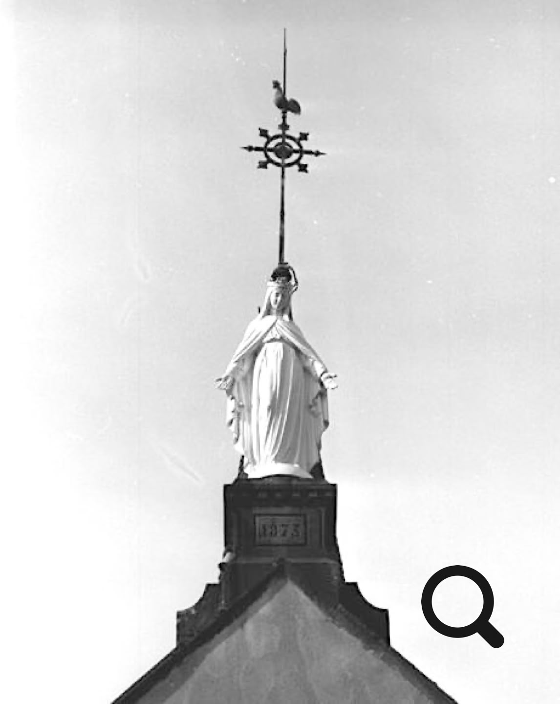 Statue sur un toit avec une flèche ornée d'une croix et d'un coq au sommet.