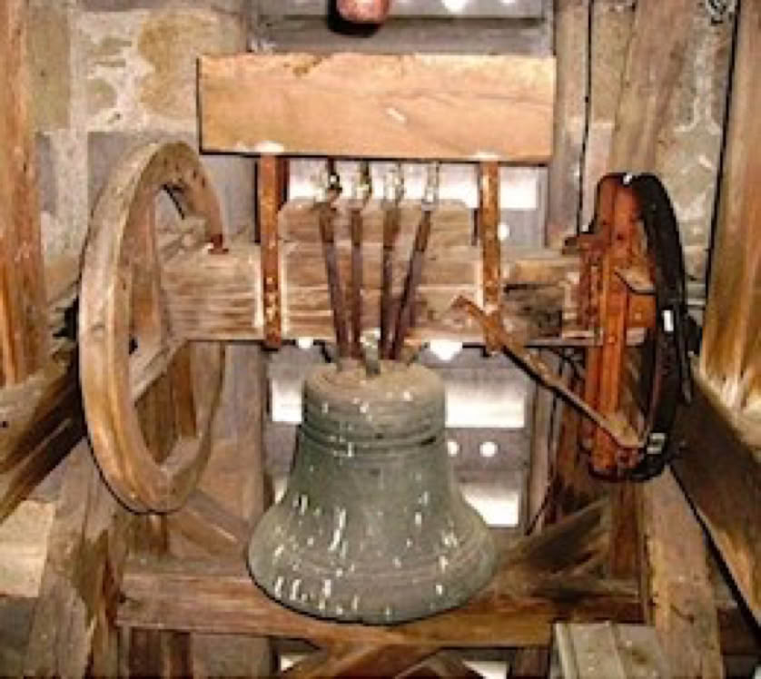 Une cloche en métal suspendue dans une structure en bois avec des roues et des cordes.