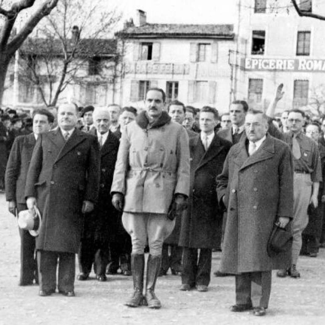 Un groupe de personnes marchant dans la rue, avec des bâtiments en arrière-plan.