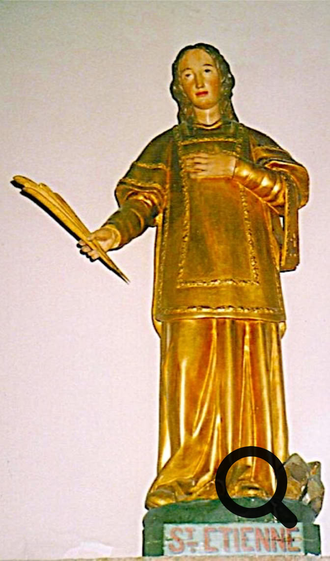 Statue dorée d'une personne debout tenant une palme, avec une inscription "St Etienne" à la base.