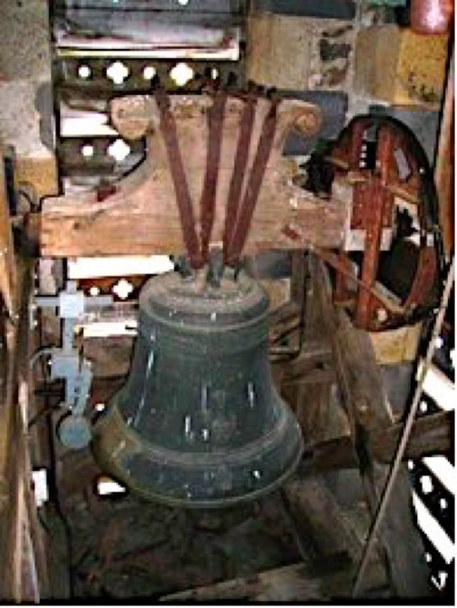 Cloche en métal suspendue dans une structure en bois avec des câbles et des poulies autour.