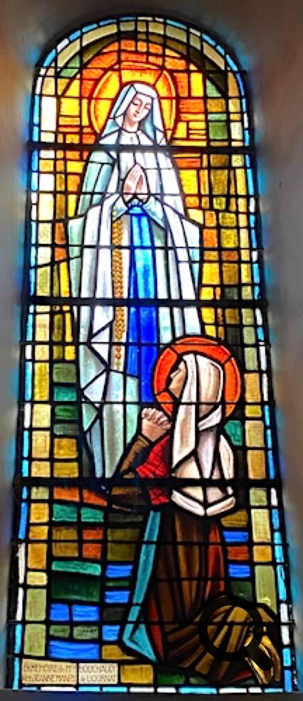 Vitrail représentant deux figures religieuses, l'une debout avec une auréole, l'autre agenouillée, entourées de motifs géométriques colorés.