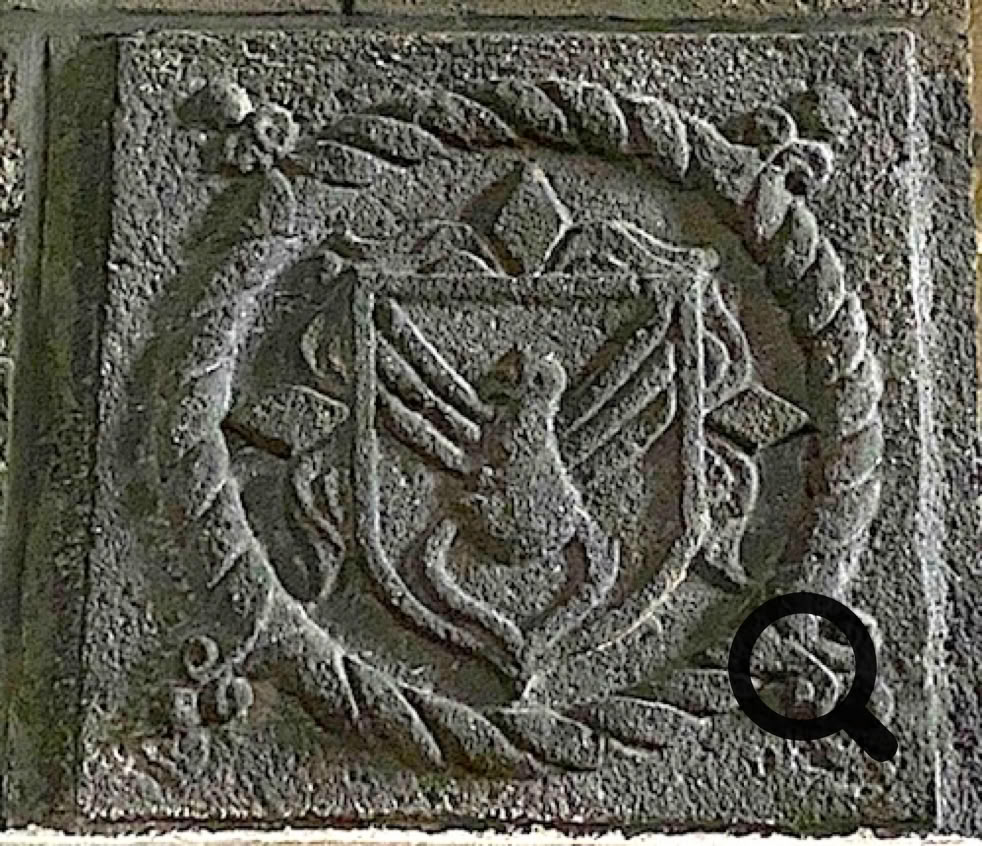 Bas-relief en pierre représentant un blason avec un oiseau stylisé au centre, entouré d'une corde torsadée et de motifs géométriques.