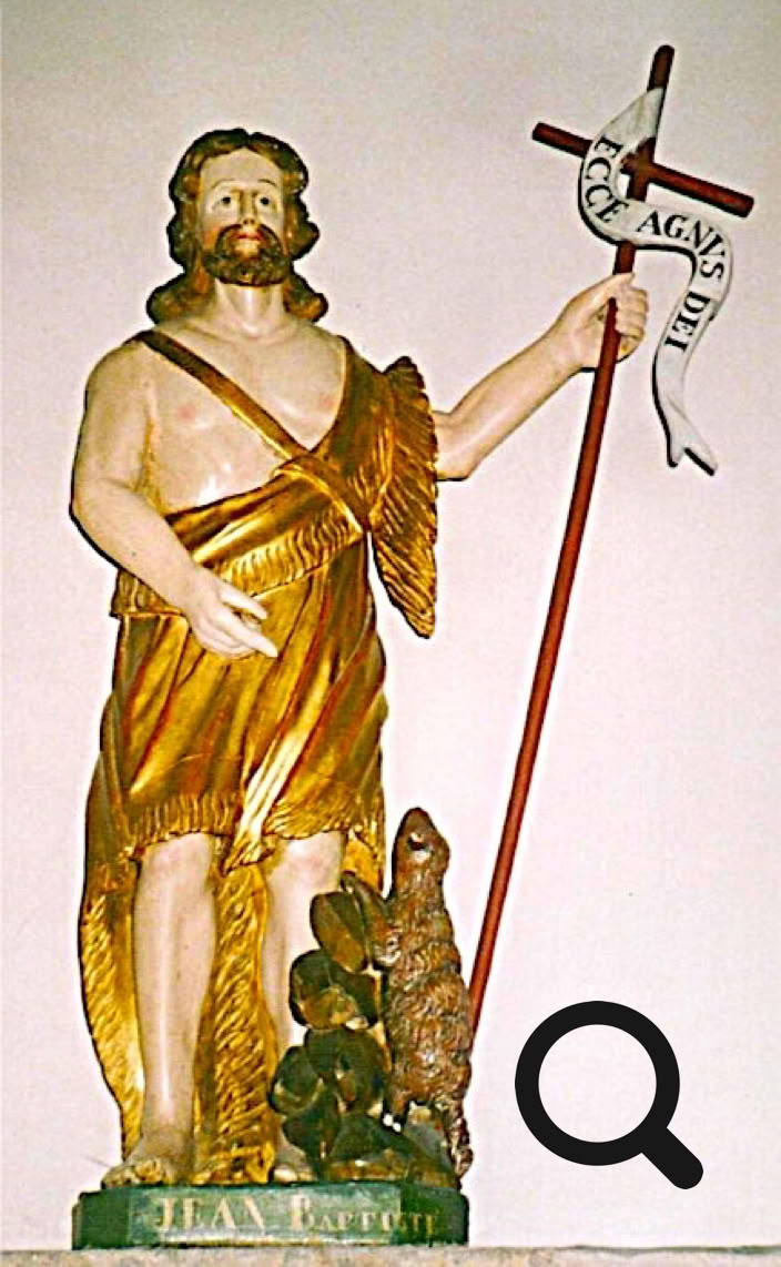 Statue d'une figure masculine barbu portant une tunique dorée, tenant une croix avec un ruban, et un agneau à ses pieds.