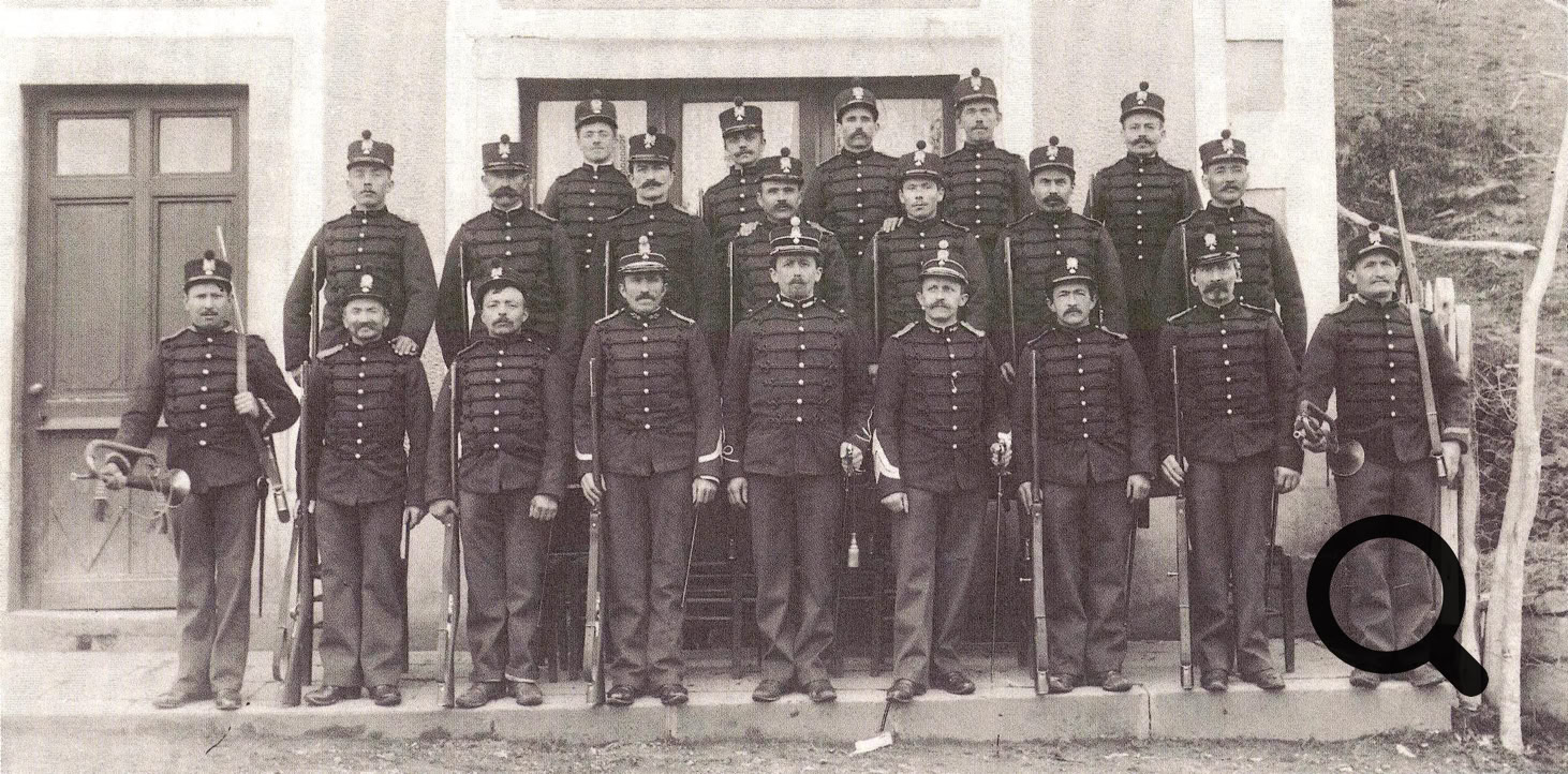 Groupe de personnes en uniforme posant devant un bâtiment.