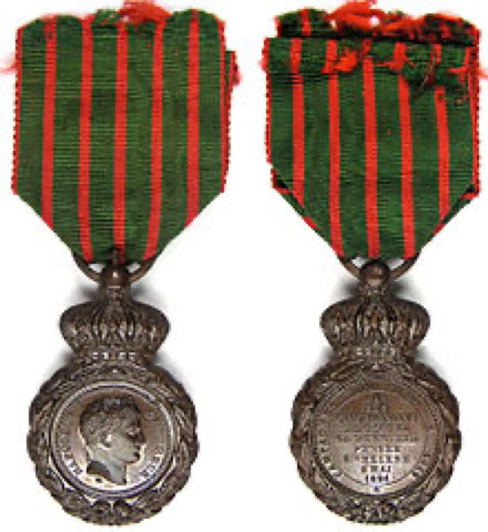 Deux médailles avec rubans verts et rouges, l'une montrant un profil de visage et l'autre avec des inscriptions.
